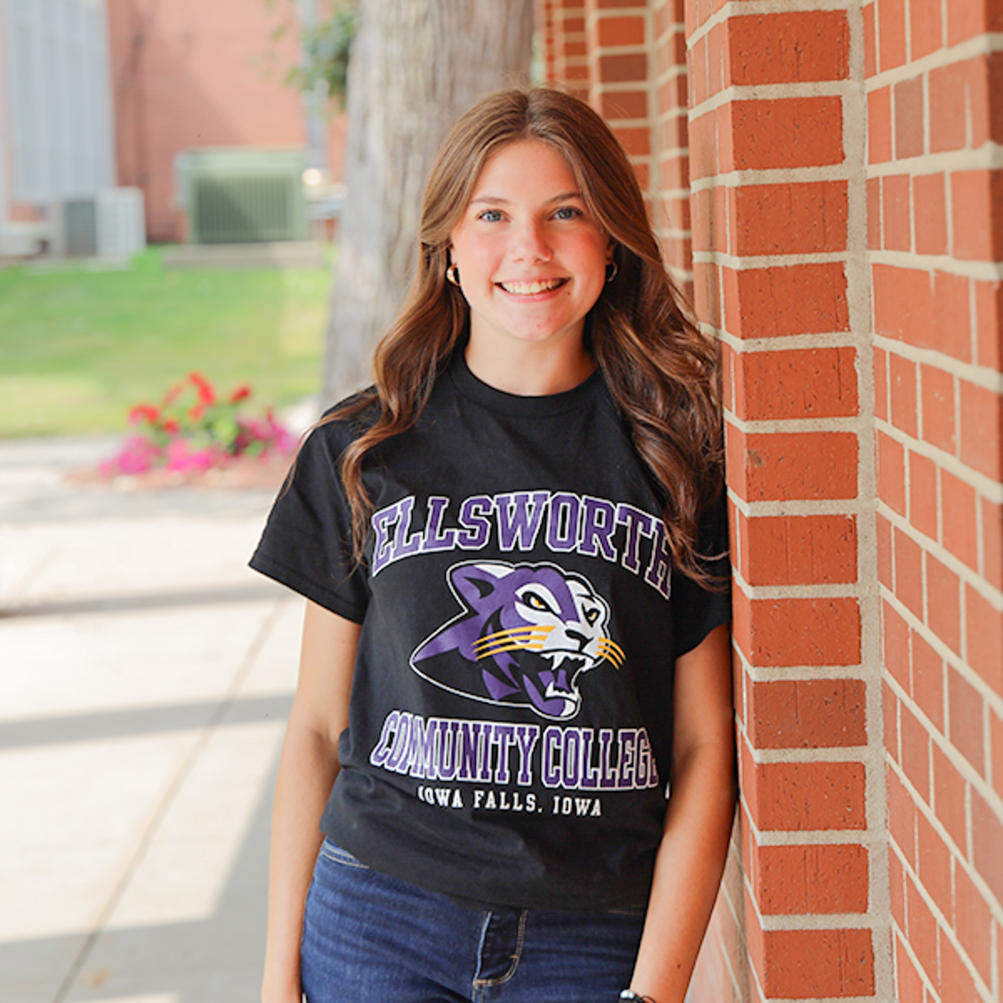 Jana leaning against the Gentle Student Center building