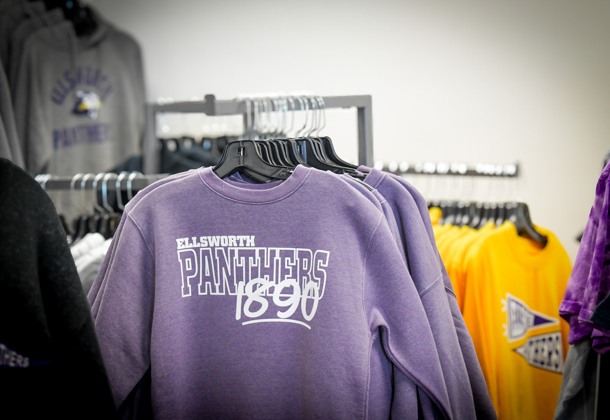 Purple Panther crewneck sweatshirt hanging in The Panther Shop. 
