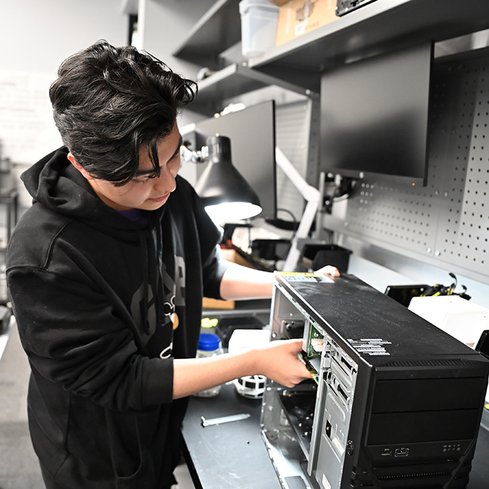 student working on the inside of a computer