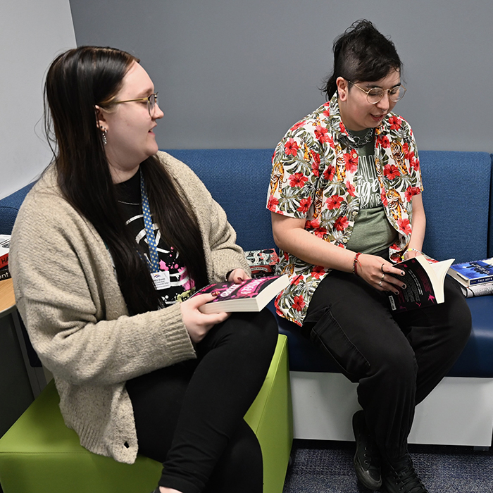 two female students sitting discussing book