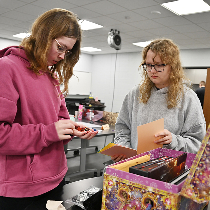 two female students looking in game box