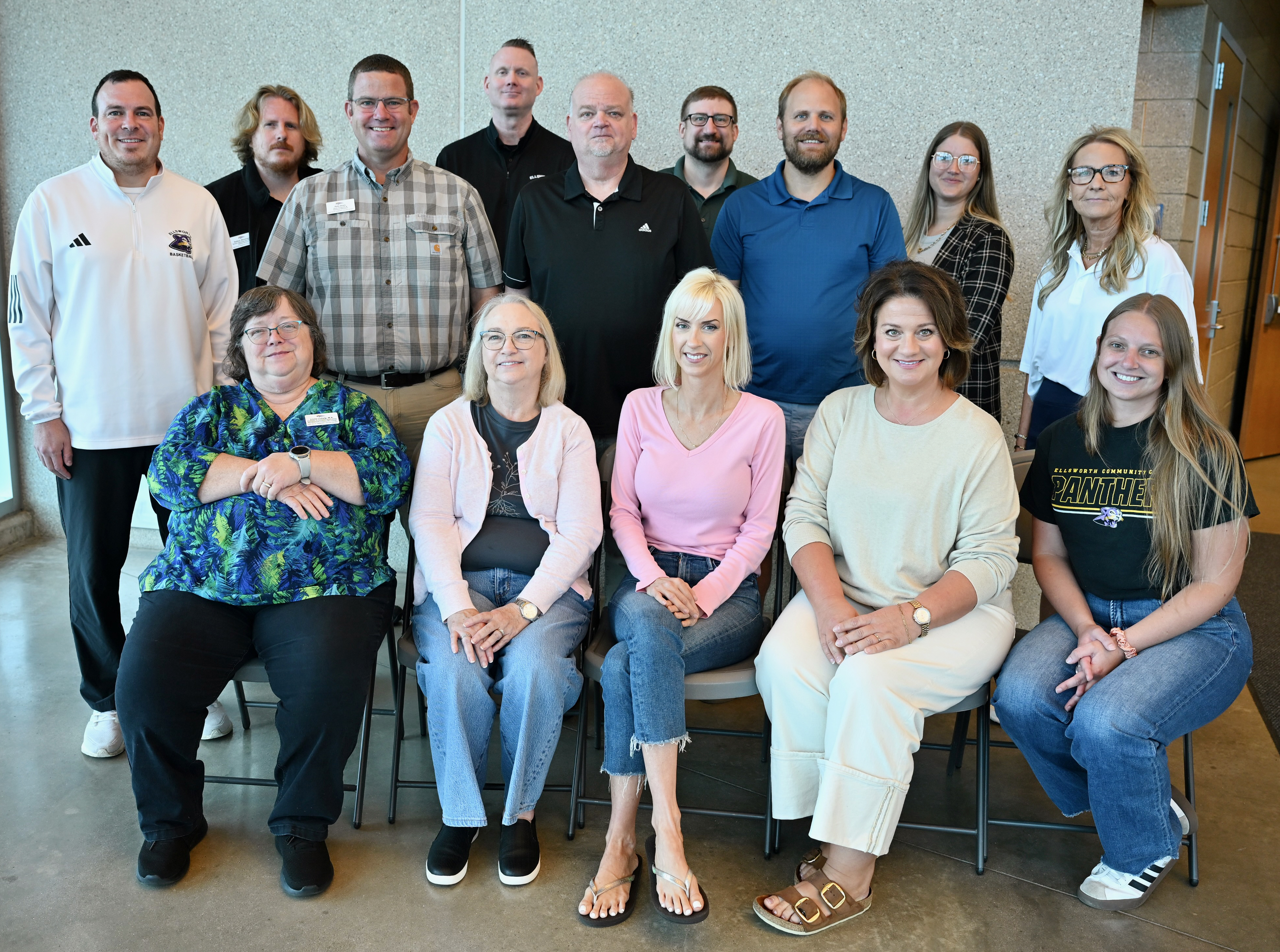 five Iowa Valley employees seated with nine standing behind them