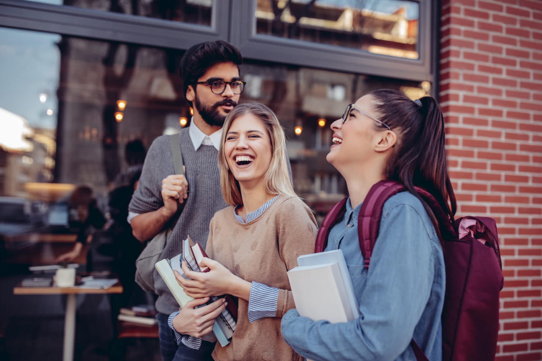 Cropped shot of three happy students talking on the street